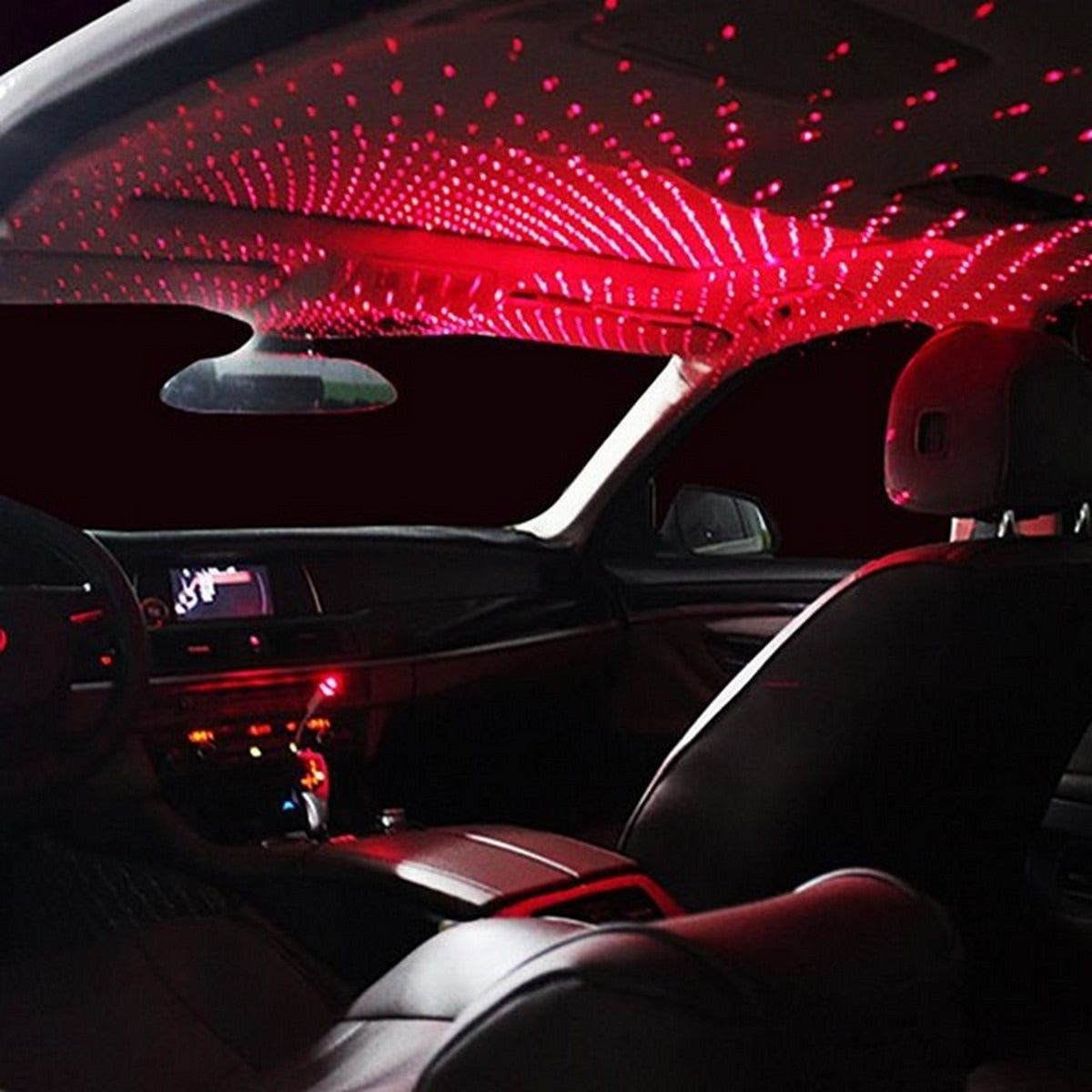 Car interior lit up with a red LED galaxy star projection on the ceiling